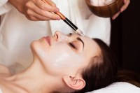 Beautiful woman with facial mask at beauty salon. Spa treatment